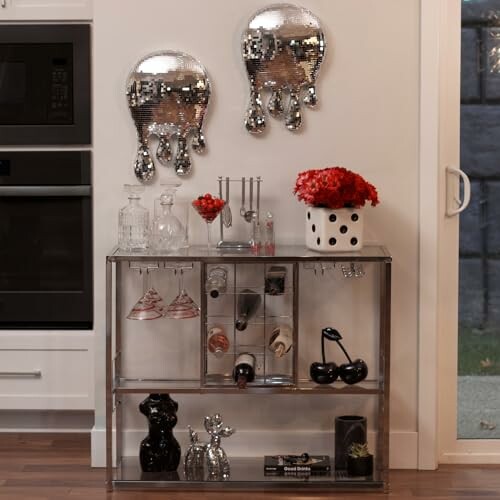 Modern kitchen with artful wall decor, glassware, and red flowers.