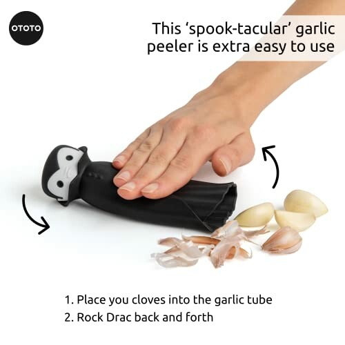 Hand using a Dracula-themed garlic peeler with cloves.