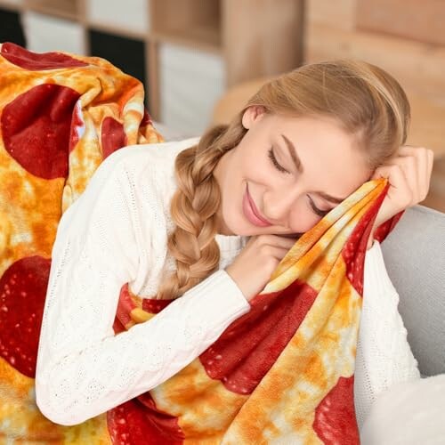 Woman snuggling with a pepperoni-patterned blanket on a couch.